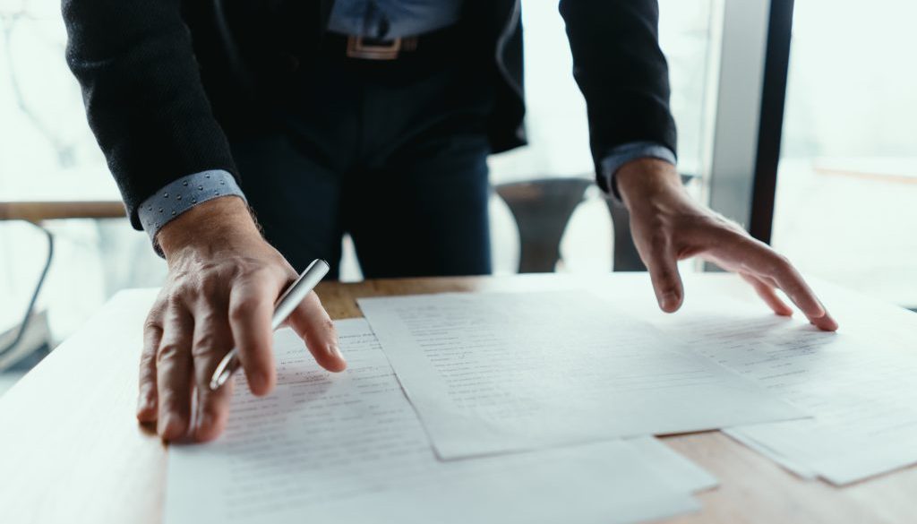 Successful business man signing documents in a modern office Successful business man signing documents in a modern office